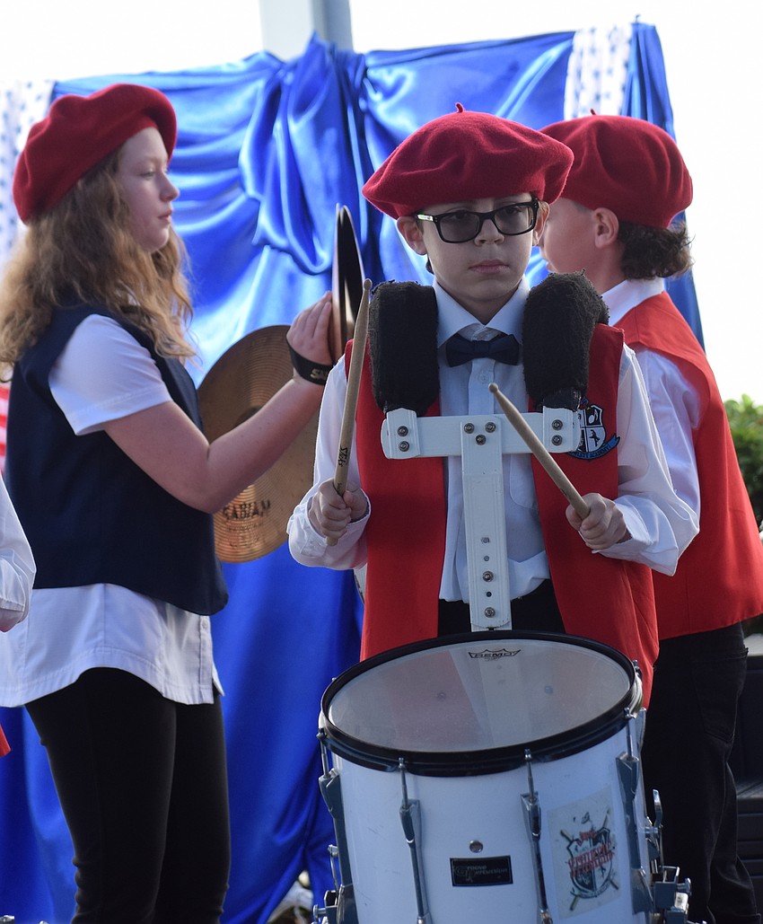 Fifth grader Benjamin Wilson-Fajardo hammers on the drums during a ceremony to honor veterans at Rowlett Academy.