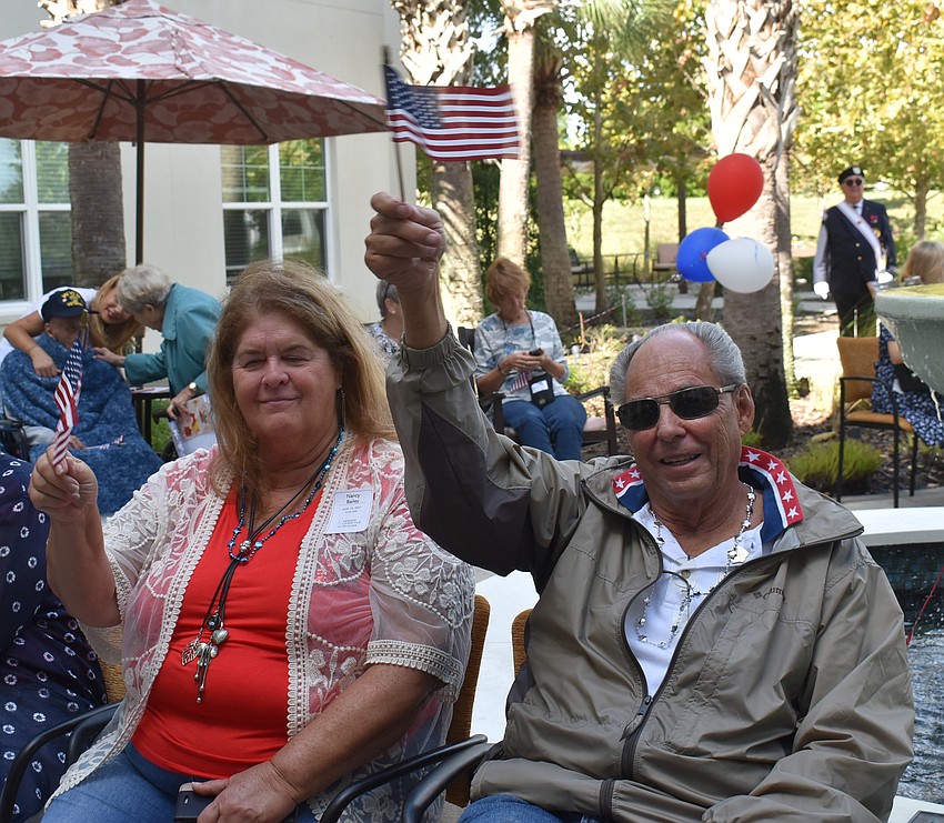 Nancy and Dave Bailey of Parrish wave American flags to patriotic music during the Nov. 10 ceremony at The Sheridan in Lakewood Ranch.