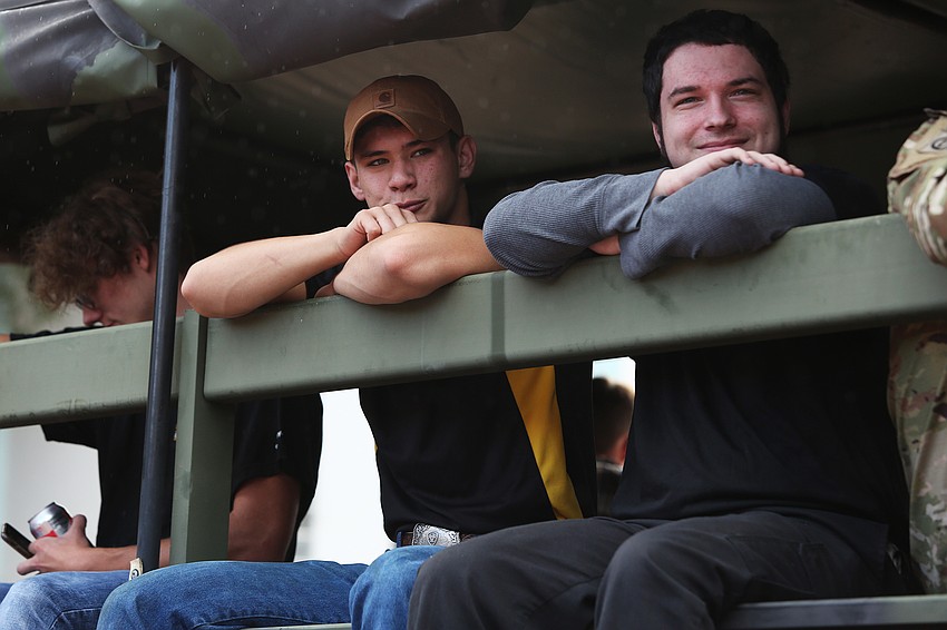 Army members ride along in a truck.