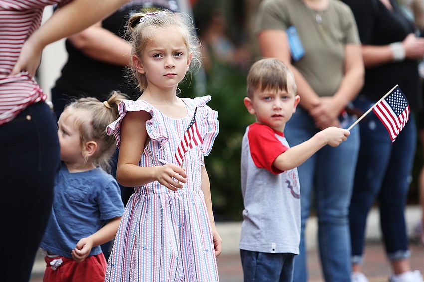 Grace Bruessow waves her flag along with siblings Ben and Liam.