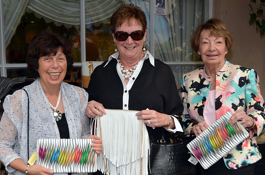Lynne Miller, Betsy Patterson and Darla Sampen shops fashionable bags from Patchington at St. Michael's Women's Guild Fashion Show and Luncheon.