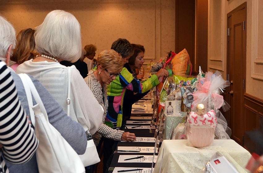 Guests bid on items in a silent auction before being seated for lunch and the fashion show.