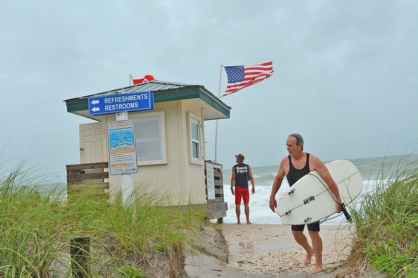 Victor Appel trudges back to the Lido Beach parking lot a surf session ahead of Tropical Storm Hermine.