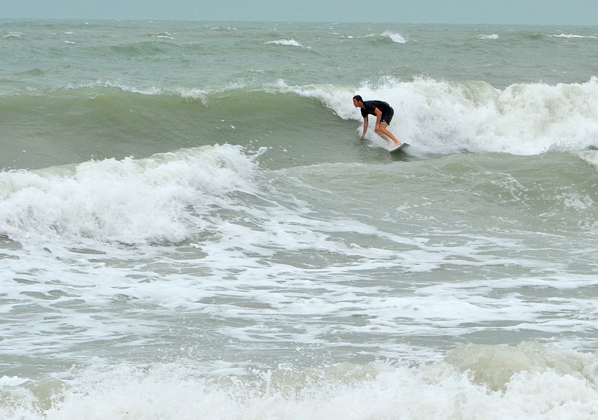 Blue Dolphin Cafe co-owner Robbie Ball surfs off of Lido Beach as Tropical Storm Hermine approaches.