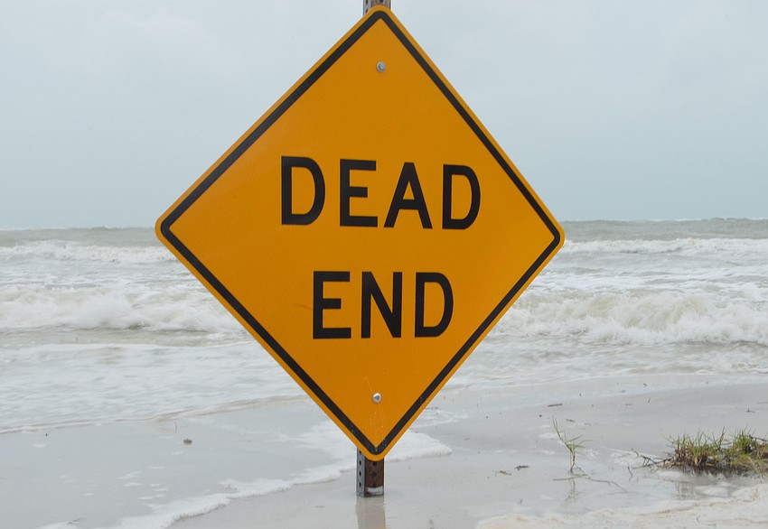 Sea water lapped over the “dead end” sign at the end of Avenida Messina. Beach goers and locals made their way down to Beach Access 2 to take pictures of the growing waves.