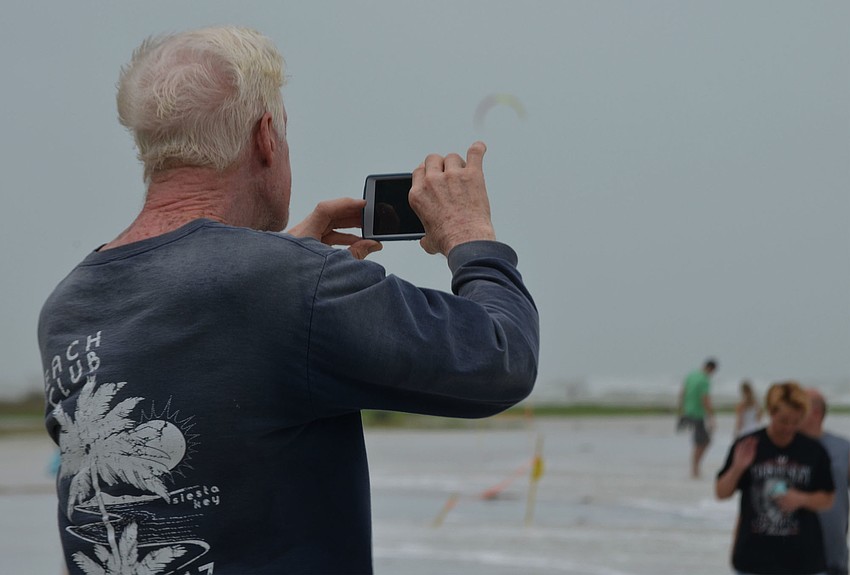Siesta Key resident Charlie Davis takes pictures of the rising surf between Beach Accesses 2 and 3. Davis said he isn’t worried about the storm. “It doesn’t happen that often, but it’s kind of interesting when it does,” Davis said.