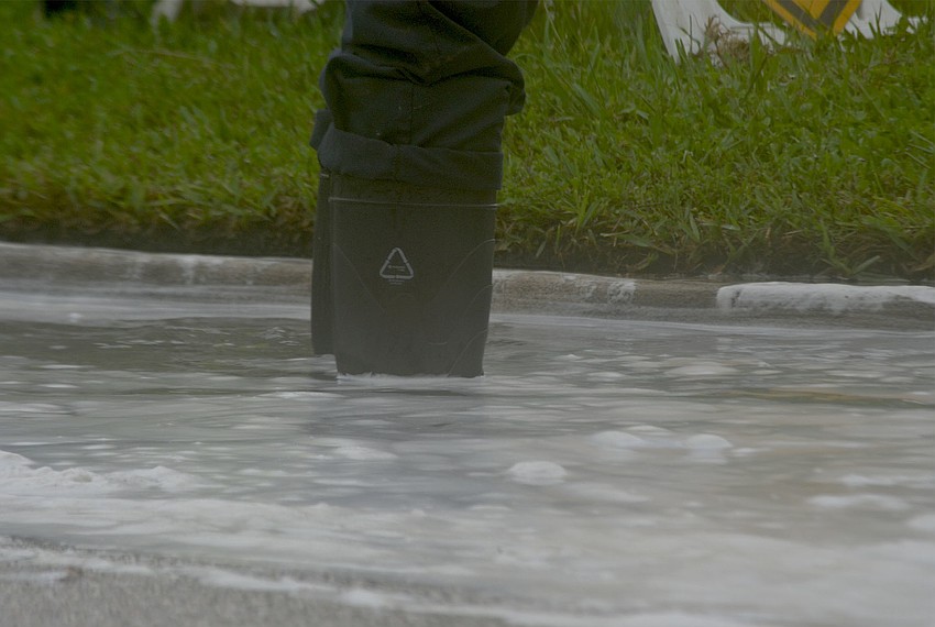 Sarasota County employee Jason Wann stands in a water at the corner of Avenida Messina and Avenida Veneccia.