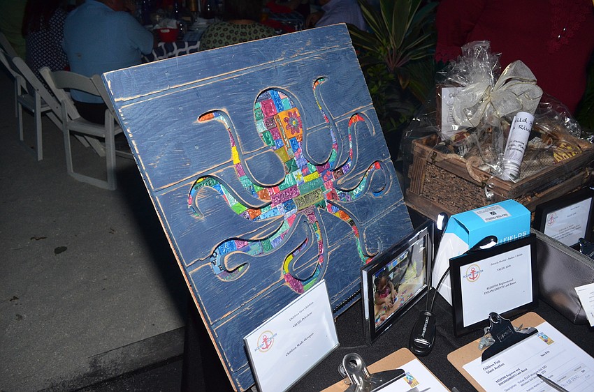 Silent auction items line the tables in front of the dance floor. This piece of art was created by volunteers Robin Shapiro and Randy Fox with a group of 17 students from the  Children First - Helen R. Payne Annex childcare facility.