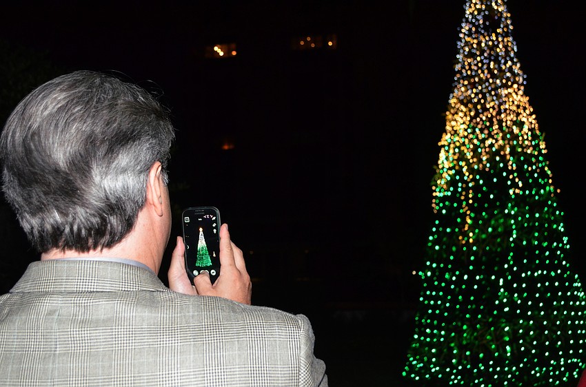 Guests take photos of the bromeliad tree after being lit.