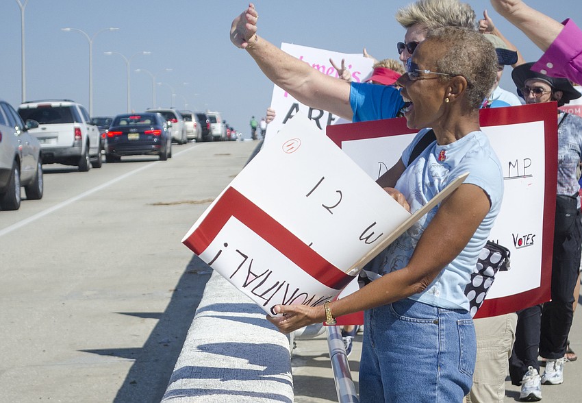Pat Singletary cheers as passing cars honk in agreement.
