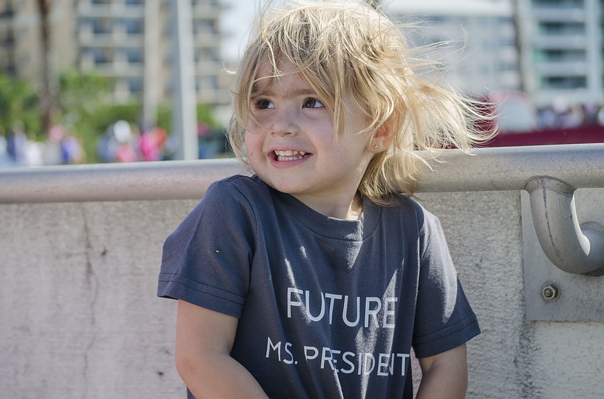 Olivia McGettigan smiles as fellow marchers stop to take her photo.