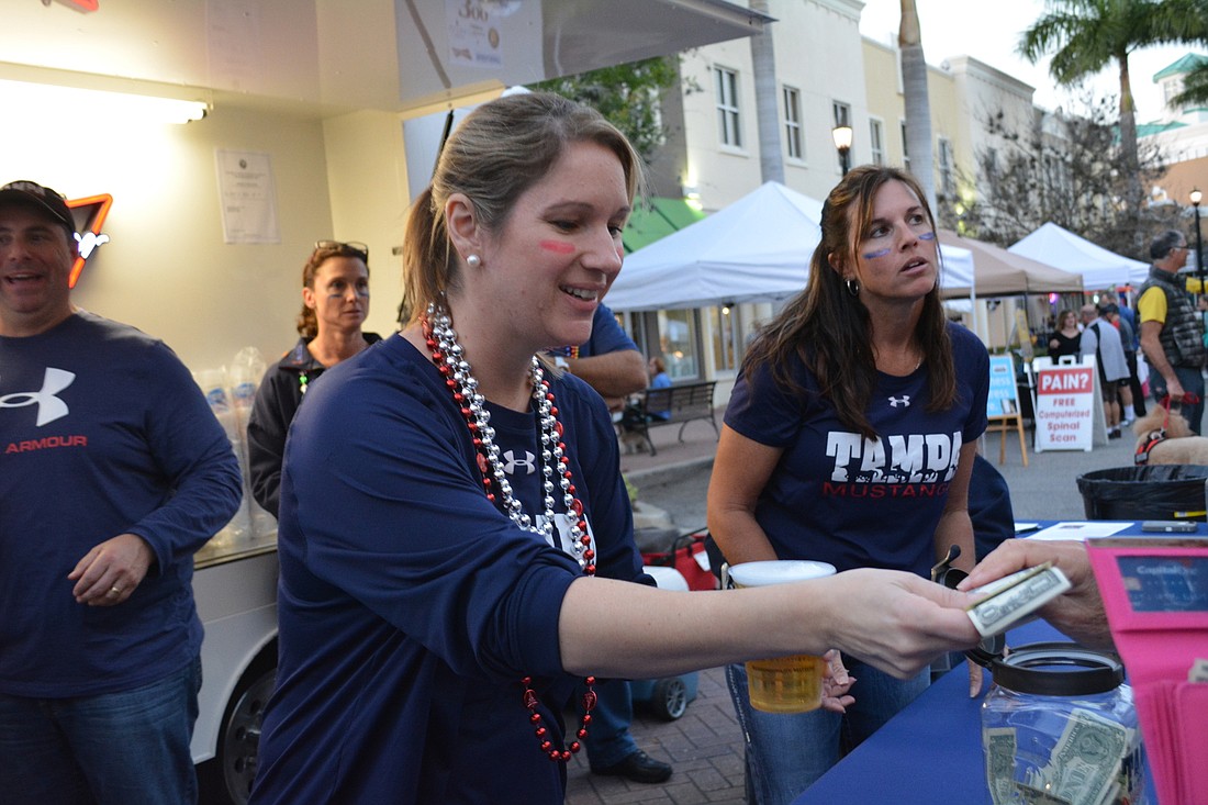Lakewood Ranch&#39;  s Anna Mulligan serves beer and takes money on behalf of the Feb. 3 benefitting charity, Tampa Mustangs, for Music on Main.