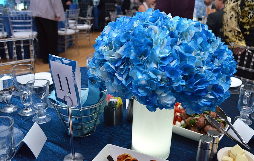 The floral centerpieces, tablecloths, napkins and table number signs all went along with the blue and white color scheme.