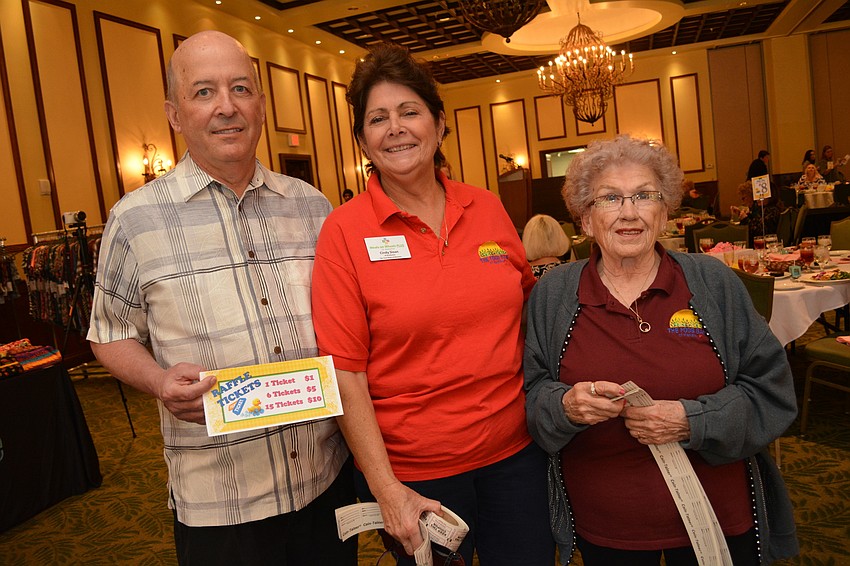 Food Bank board member Terry Gubbins assists Food Bank Director Cindy Sloan and volunteer Mary Meyer with raffle ticket sales.