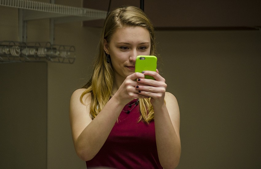 Pine View student Abby Hostetler takes a photo using James Balog'  s phone. The award winning photographer asked the Sarasota student to take a photo of the press room.