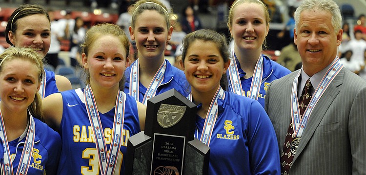Members of the Sarasota Christian girls basketball team, along with coach Brett Morrow, pose for pictures with the Class 2A state runner-up trophy.