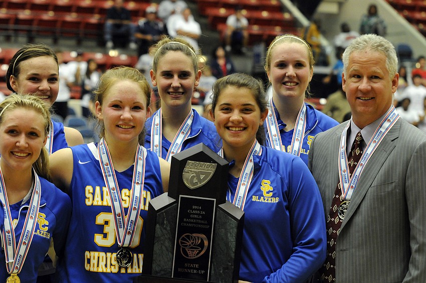 Members of the Sarasota Christian girls basketball team, along with coach Brett Morrow, pose for pictures with the Class 2A state runner-up trophy.