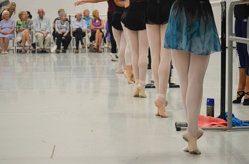 The dancers do a sequence of steps at the bar to warm up