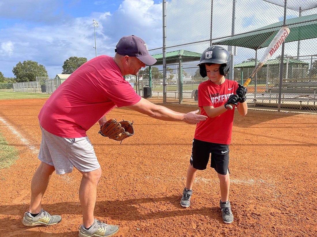 Zack Rumbaugh of Lakewood Ranch gives son Brandt some pointers on his batting stance on one of the baseball fields in Lakewood Ranch Park. Citizens say more baseball and softball fields are needed around Manatee County.