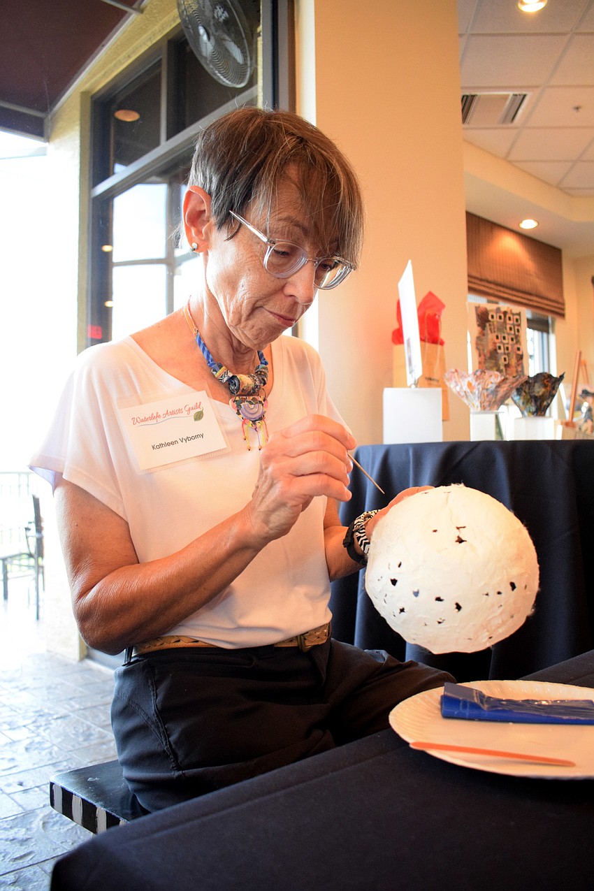 Waterlefe's Kathleen Vyborny works on a molded bowl. She'll use silk fiber and paper clay to mold her bowls and use tissue paper to add color.