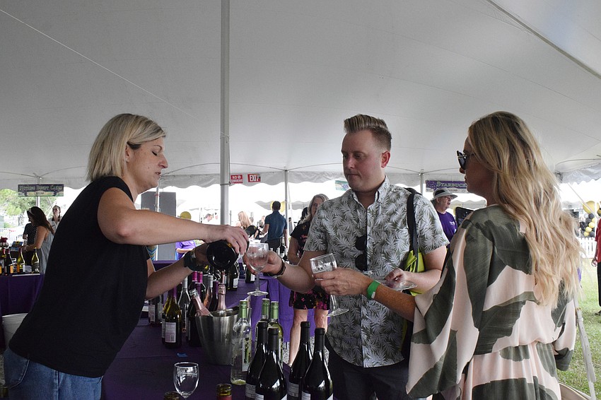 Beth Bandy, a volunteer for Gallo Winery, serves wine to Sarasota's Matt Craft and Heather Hawley.
