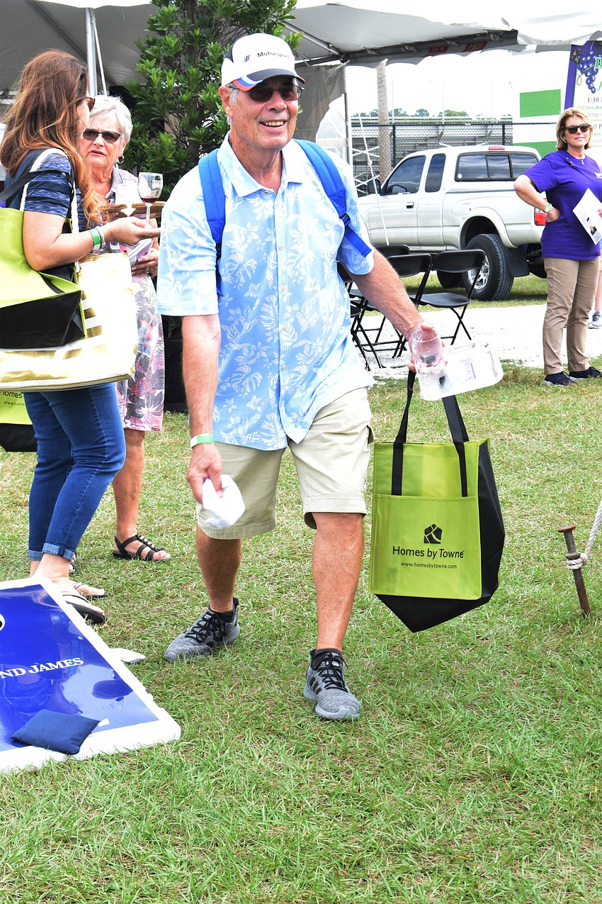 Osprey's Jack Noll wins a bottle of wine after playing a game of cornhole.
