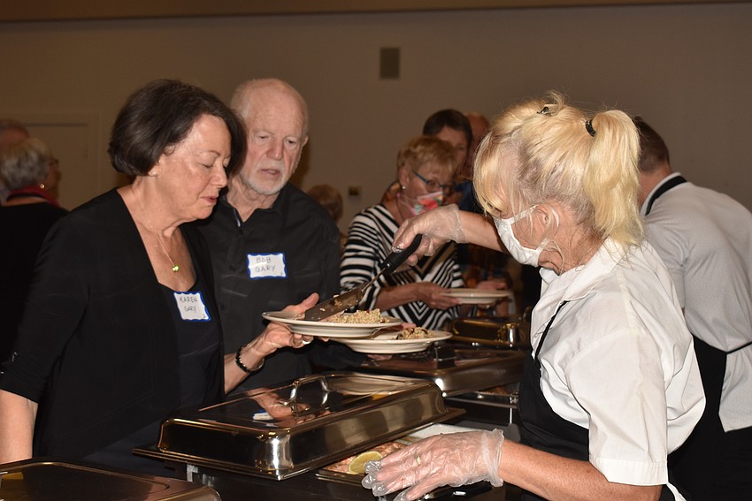 Attendees waited to be served at a buffet style dinner.