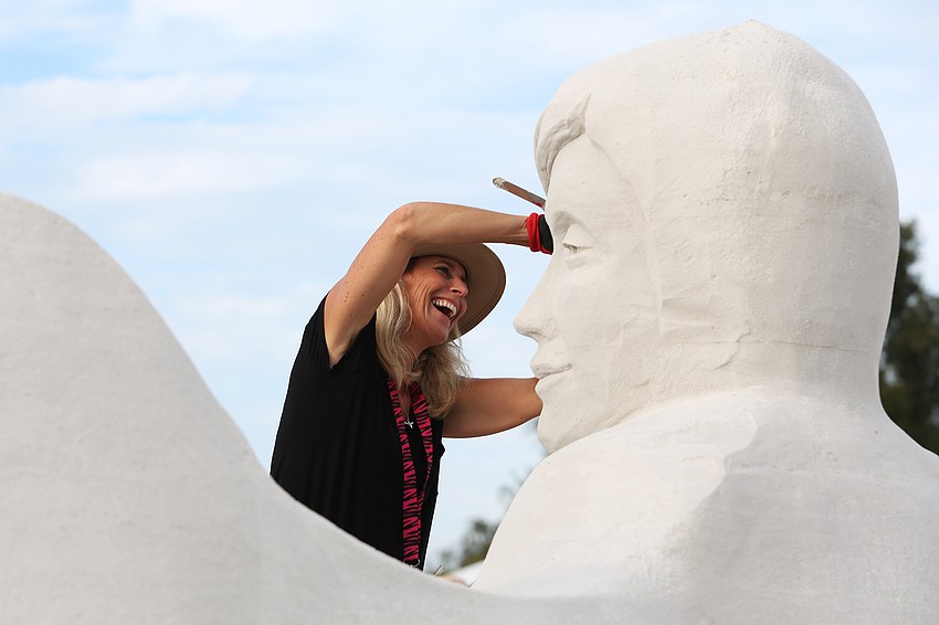 Laura Cimador Gowdy carves an expression into the sculpture.