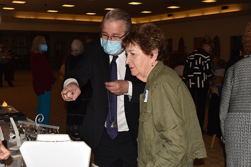 Rabbi Stephen Sniderman and Sharon Schreiber look at the jewelry on display.