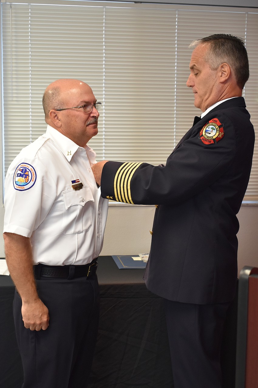 On Wednesday morning, Fire Chief Paul Dezzi (right) pinned John Elwood (left), who became a training captain.