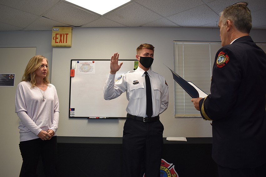 Shelley Jones looks on as her son Tanner Broxson swears an oath to become a firefighter-paramedic. Fire Chief Paul Dezzi swore Broxson in.
