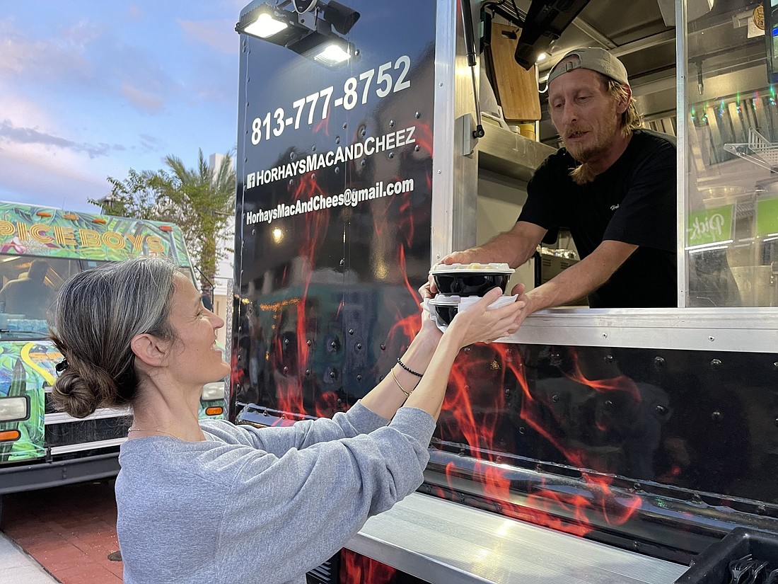 Lakewood Ranch resident Crystena Starre picks up an order from "Horhay" of the Horhay&#39;s Mac & Cheez food truck at Waterside on Nov. 17. Food trucks will soon be allowed for social functions inside CDD 2 in Lakewood Ranch.