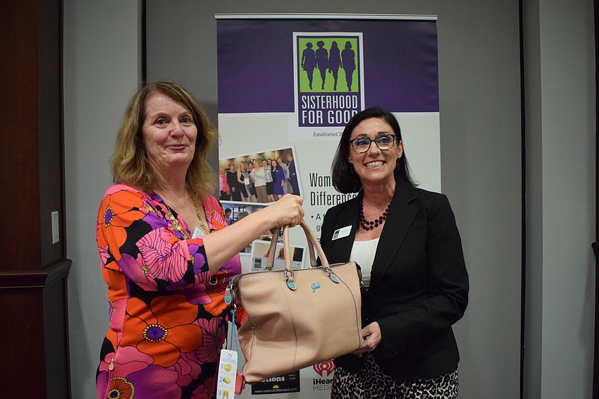 Amy Gorman, the president of Sisterhood for Good, presents Sarasota's Brenda Kleiber with her winnings.