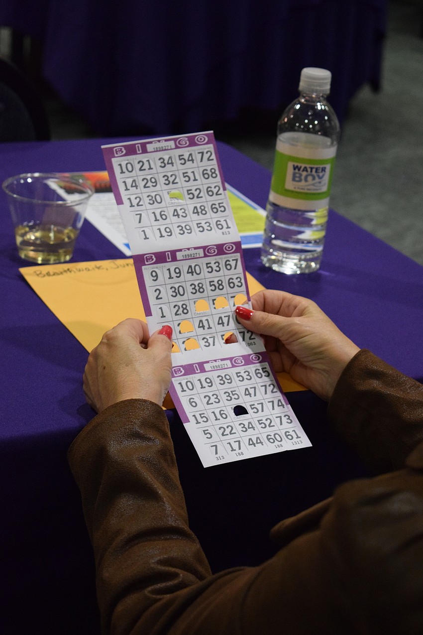 Women punch their Bingo cards.