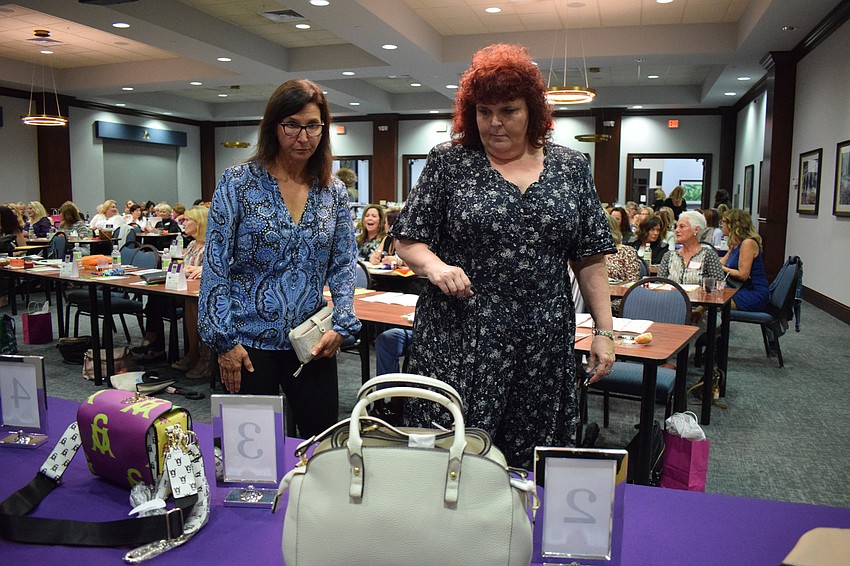 Chris Byrd and Jodi Allen take a look at the purses that are available as prizes for winning one of the nine rounds of bingo.