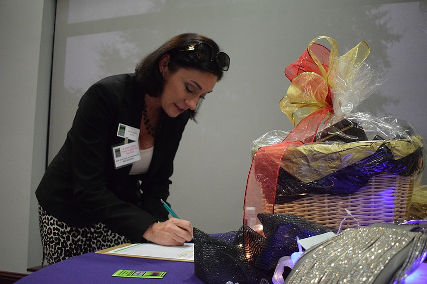 Sarasota's Brenda Kleiber puts in a bid for a Glitz and Glam basket in the silent auction.