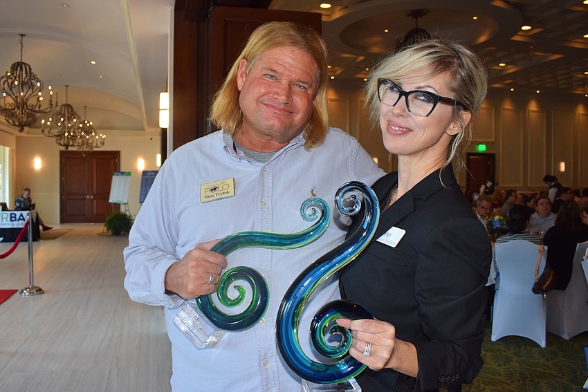 Ron Trytek of the Sarasota Polo Club and Karen Medford of Sirius Day Spa compare their Sandies awards.