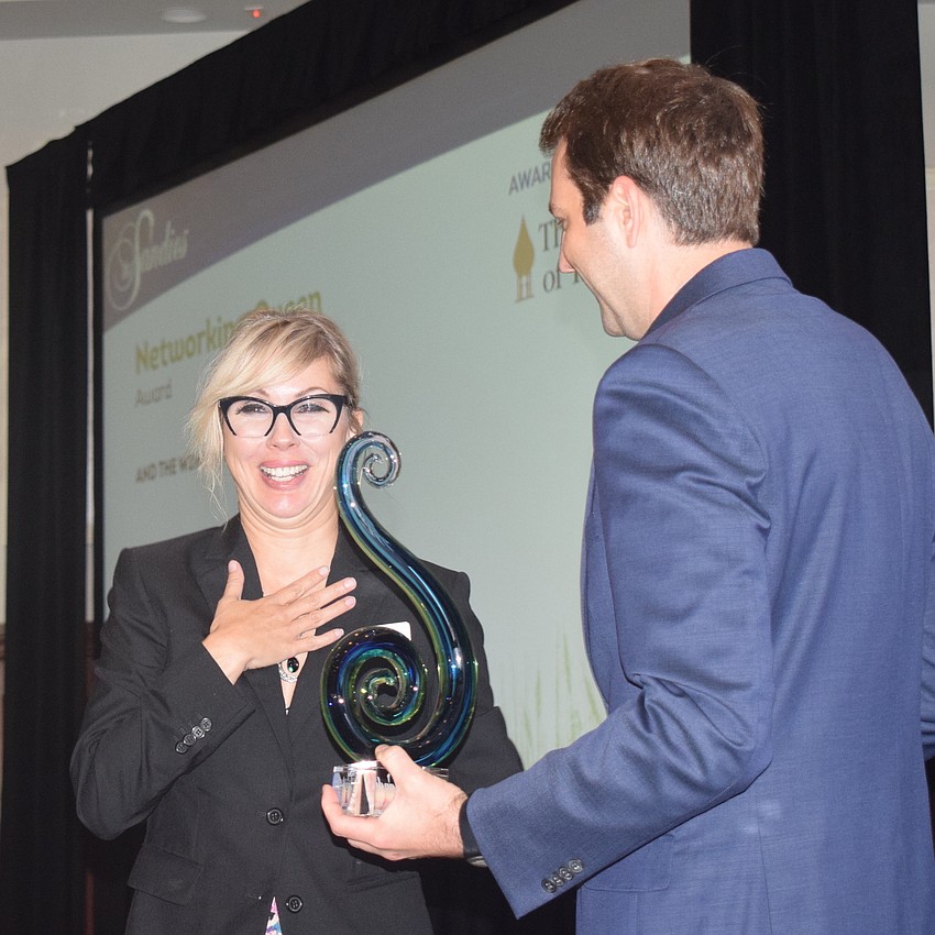 Karen Medford catches her breath as she receives her Networking Queen award from LWRBA Vice President Dan Sidler.