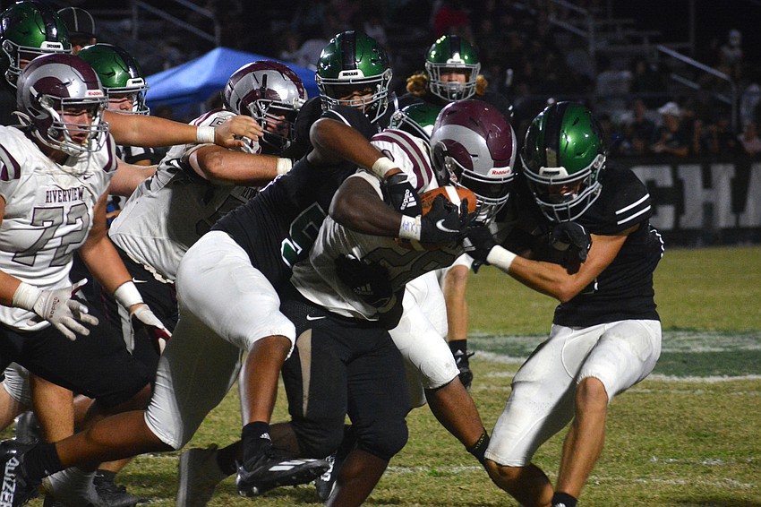 Rams sophomore running back Ahmad Hunter gets wrangled by three Indians defenders.