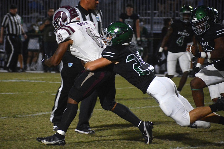 Rams senior running back Jay'den Birch fights through a tackle by Venice junior Elliot Washington.