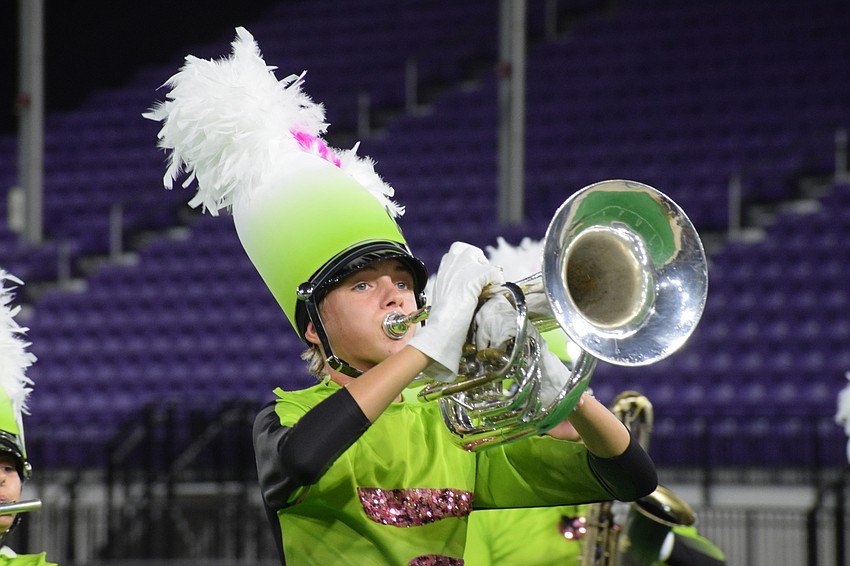 Kasey Wade with the Marching Band of Pirates watches the drum majors as he marches and plays.