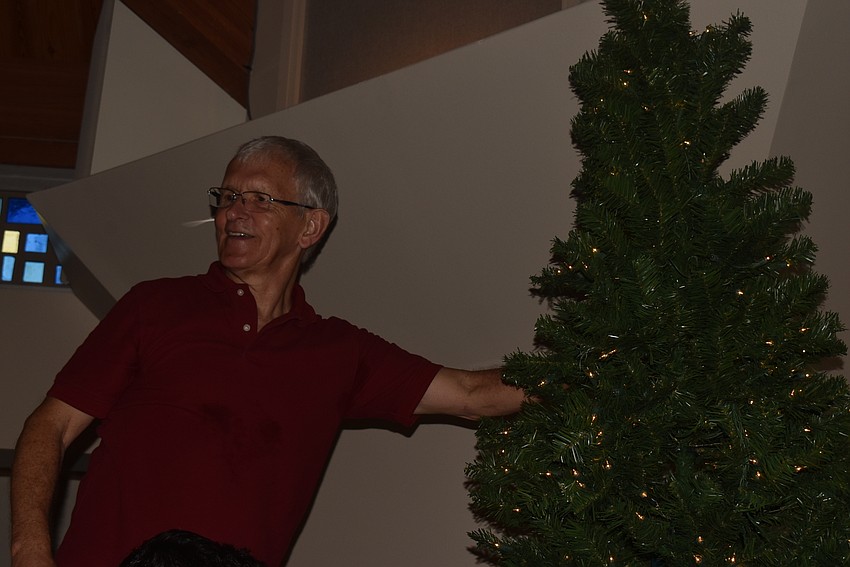 Steve Gunderson fluffs the boughs on a tree in the sanctuary.