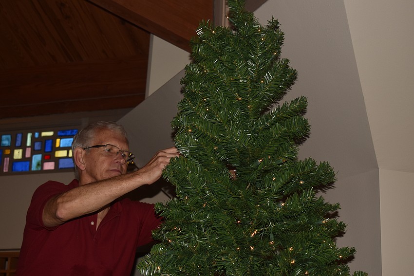 Steve Gunderson fluffs the boughs on a tree in the sanctuary.