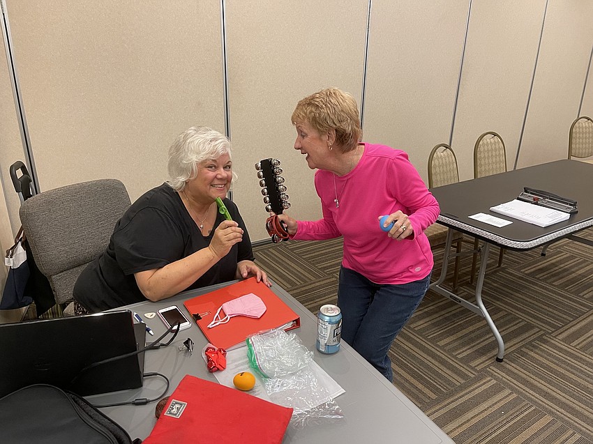 Alice Baumann and Clare Barone share a laugh and jokingly play a couple of instruments.