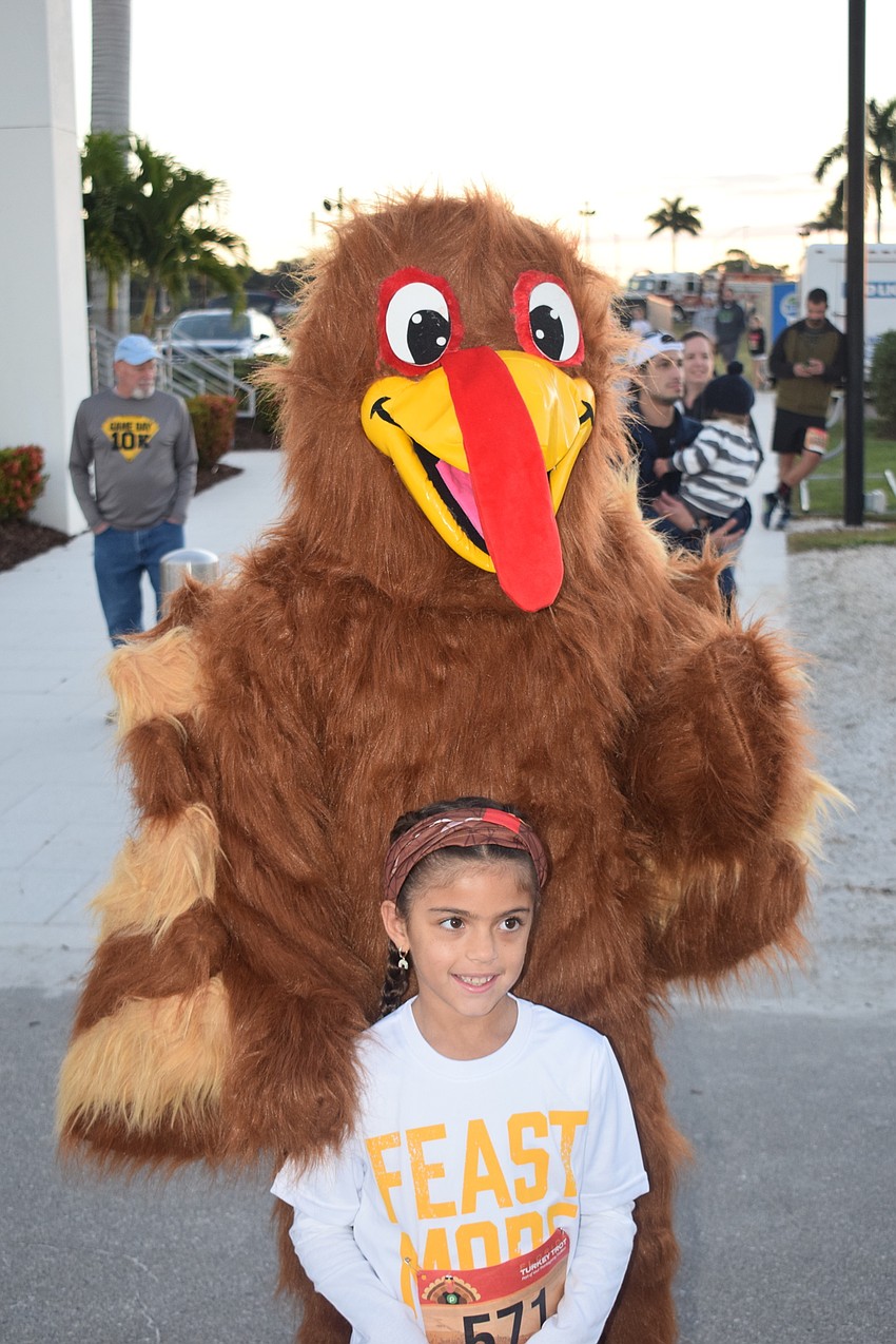 Sarasota 8-year-old Catalina Poole meets Troy the Turkey (Kaden Bowles of Sarasota) at the Florida Turkey Trot.