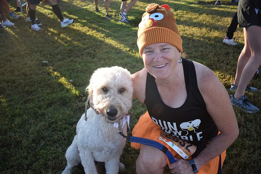 Newton, a 3-year-old Goldendoodle, joins owner Karen Bray of Venice in running the Florida Turkey Trot 5K.