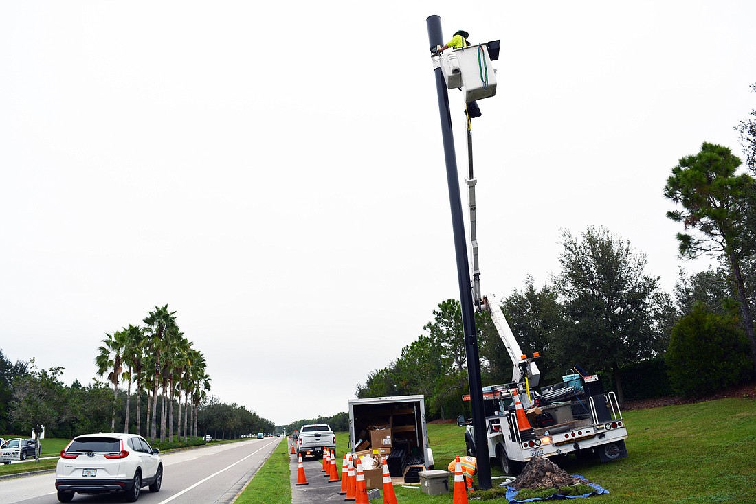 A crew from HP Communications works on installing a small cell pole along Lakewood Ranch Boulevard at Players Drive. Small cell sites have a coverage radius up to 2,000 feet. File photo.