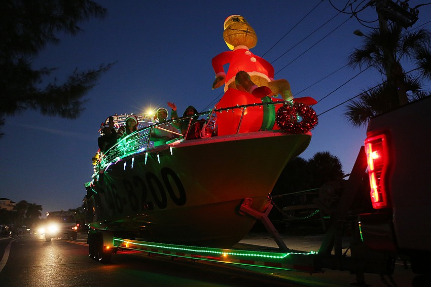 Groups decorate boats in cheery Christmas stylings.