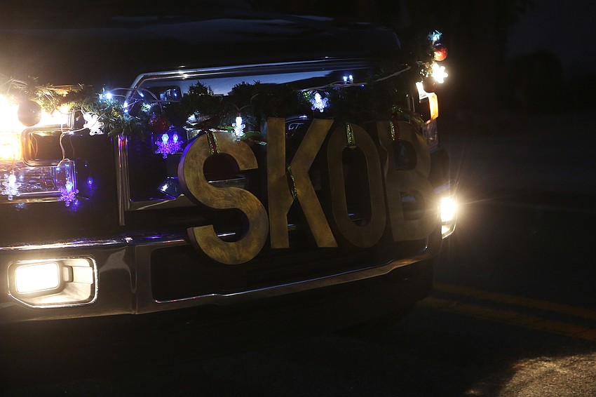 Groups decorate boats in cheery Christmas stylings.