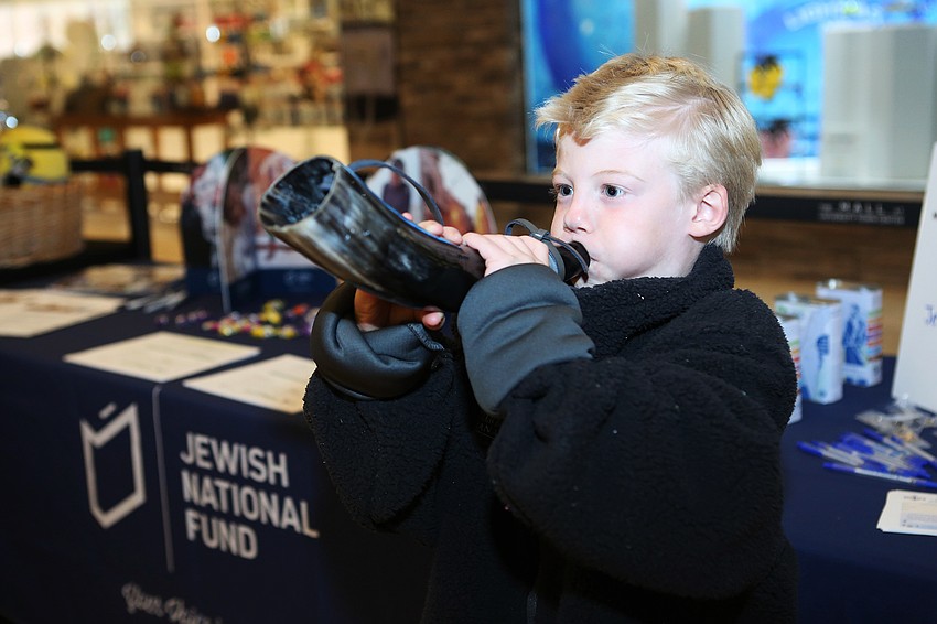 Victoria Dumbaugh blows a shofar to announce the start of Hanukkah.